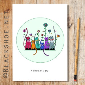 May include: A greeting card featuring a circular illustration of six colourful cats sitting in a row with flowers and hearts. The text "A little note to say..." is at the bottom of the card.