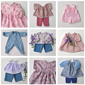 May include: Nine different doll outfits for a doll making or doll clothing project. The outfits include a pink floral dress, a pink and white gingham dress, a blue floral dress, a purple floral dress, a pink linen dress, a blue and white floral dress, a blue jumpsuit, a blue and white gingham dress, and a pink and white gingham jumpsuit.