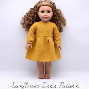 May include: A doll with long curly brown hair wearing a mustard yellow long-sleeved dress with a gathered waistline. The text Sunflower Dress Pattern is printed in black script at the bottom of the image against a plain white background.