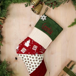 以下が含まれることがあります： 雪だるまやヒイラギの模様がついた赤、緑、クリーム色のクリスマスストッキング。ストッキングには緑色の刺繍で「セシリア」という名前が書かれています。