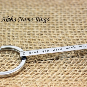 May include: A silver keychain with a metal tag that reads "I need you here with me".