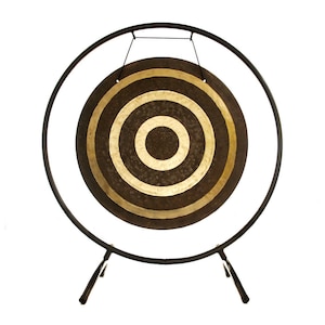 May include: A circular bronze gong with a dark, textured surface and two concentric polished gold rings, suspended by black cords from a thin, black metal circular frame that is supported by two angled legs at the base of the structure.