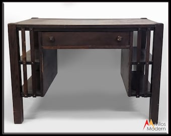 May include: A dark brown wooden desk with a single drawer and open shelves on either side. The desk has a simple, geometric design.
