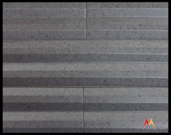 May include: Close-up of a gray stone wall tile with a textured, horizontal, ridged pattern. The tile is divided into four rectangular sections. The surface has a speckled appearance. The bottom right corner features the "Milos Modern" logo.