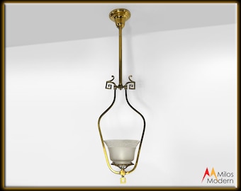 May include: A brass pendant light fixture with a white glass shade. The fixture has a Greek key design and a square base.