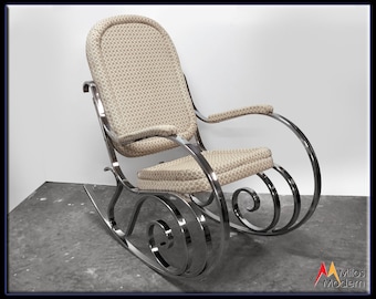 May include: A chrome rocking chair with a beige patterned fabric seat and back.