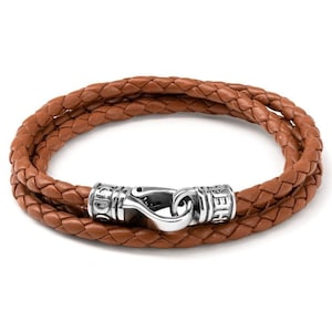 May include: A brown leather bracelet with a silver clasp. The clasp has the word "HELLER" engraved on it.