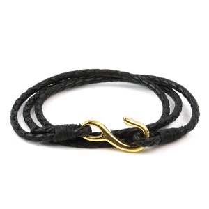 May include: A black leather bracelet with a gold hook clasp. The bracelet is braided and has a simple design.