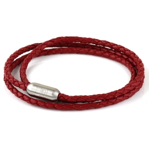 May include: A red leather bracelet with a braided design and a silver clasp.