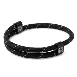 May include: Black double-strand rope bracelet with silver metal accents and the letter "B" engraved on each accent.