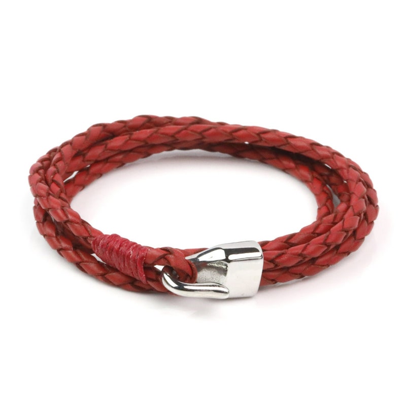May include: A red leather braided bracelet with a silver clasp.