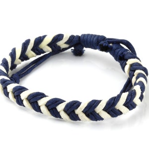 May include: A braided bracelet with a navy blue and white pattern.