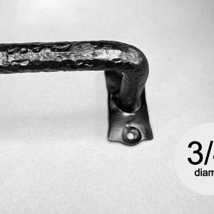 May include: A black metal curtain rod with a textured, hammered finish and a mounting bracket. The rod features a 1.9 cm diameter as indicated by the text overlay. The hardware includes a flat base with a pre-drilled hole for installation.