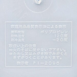 Puede incluir: Primer plano de una superficie de pl&aacute;stico blanco con texto japon&eacute;s. El texto incluye informaci&oacute;n sobre el material del producto, la resistencia al calor y al fr&iacute;o. El texto tambi&eacute;n incluye advertencias de uso.