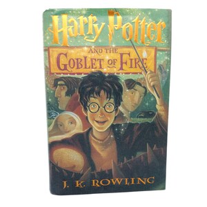 Puede incluir: Un libro de tapa dura verde con un título dorado, "Harry Potter y el Cáliz de Fuego." La portada presenta una ilustración de Harry Potter con una varita mágica, rodeado de otros personajes.
