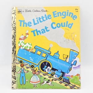 May include: A vintage children's book titled "The Little Engine That Could." The cover features a blue cartoon train, a clown, and children. The background is yellow with a price tag of 59¢.