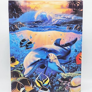 Puede incluir: Una impresión vibrante que presenta una escena marina con delfines y peces de colores. La obra de arte representa una ola rompiendo bajo un cielo de puesta de sol, con dos delfines nadando en primer plano. La imagen está llena de tonos azules, naranjas y amarillos.