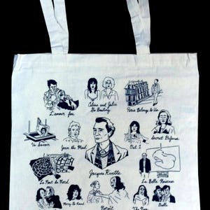 Puede incluir: Bolso tote blanco con ilustraciones negras de escenas de películas y retratos. Presenta el texto "Celine and Julie Go Boating", "Paris Belongs to Us", "Jacques Rivette" y "Up, Down, Fragile". Incluye asas blancas.