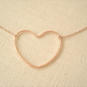 Puede incluir: Un collar de oro rosa con un delicado colgante de corazón abierto.