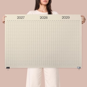 Op de afbeelding: Een grote, rechthoekige wandkalender gedrukt op een lichtbeige achtergrond. De kalender toont de jaren 2027, 2028 en 2029 in vetgedrukte zwarte tekst bovenaan. Het heeft een rasterindeling met maanden en dagen georganiseerd in kolommen.