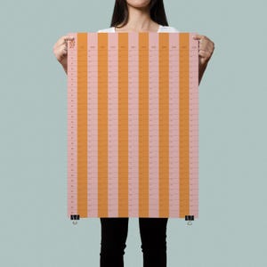 May include: A vertical wall calendar featuring alternating vertical stripes of light pink and orange. The calendar displays the years 26 and 27 in the top left corner, with months listed across the top and days numbered 1 through 31 down the side.