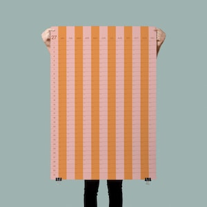 Puede incluir: Un calendario de pared vertical con rayas alternas de color naranja y rosa claro. La cuadrícula muestra los números del 1 al 31 en el lado izquierdo y los meses de enero a diciembre en la parte superior, con clips negros en la parte inferior.