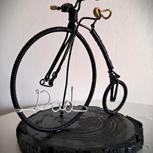 Black Penny Farthing bicycle sculpture with gold hand grips and gold seat