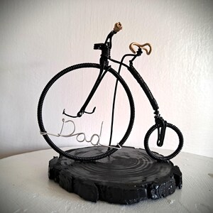 Black Penny Farthing bicycle sculpture with gold hand grips and gold seat