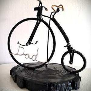 Black Penny Farthing bicycle sculpture with gold hand grips and gold seat