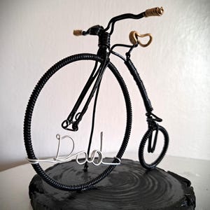 Black Penny Farthing bicycle sculpture with gold hand grips and gold seat
