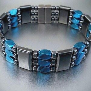 May include: A silver and blue magnetic bracelet with a row of blue rectangular beads and two rows of silver beads.