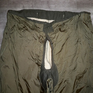 May include: A pair of olive green cargo pants with a zippered fly and a black waistband.
