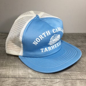 May include: A light blue and white mesh trucker hat with the text "NORTH CAROLINA TARHEELS" and a UNC logo.