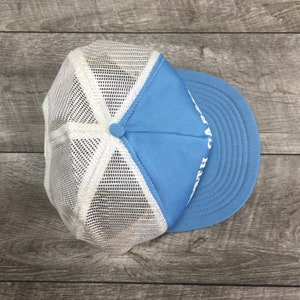May include: A light blue and white mesh trucker hat with white text that reads "H.A.T.S."