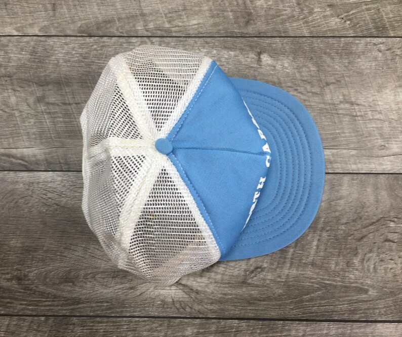 May include: A light blue and white mesh trucker hat with white text that reads "H.A.T.S."
