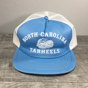 May include: A blue and white trucker hat with the text "NORTH CAROLINA TARHEELS" and a white UNC logo.