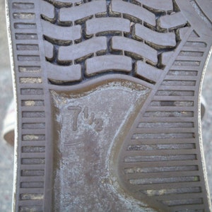 Pode incluir: Close-up da sola de um sapato marrom com uma sola texturizada. O tamanho do sapato est&aacute; marcado com "7 1/2" na sola.