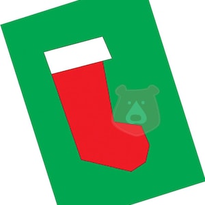 Peut inclure: Une chaussette de Noël rouge et blanche avec un revers blanc sur un fond vert.