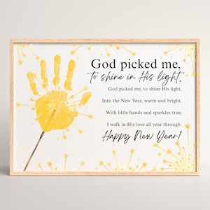 May include: A framed print with a light wood frame. The artwork features a yellow handprint with starbursts, and the text "God picked me, to shine in His light." Additional text includes a New Year's message.