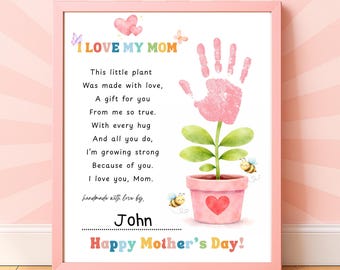 May include: A framed print with a pink border features a poem and a handprint flower. The text reads "I Love My Mom" and "Happy Mother's Day!" with the name "John" at the bottom. The artwork includes bees and hearts.