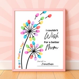 May include: A framed print with a pink border features a dandelion design created with colorful fingerprints. The text reads "I couldn't wish for a better Mom" and "Happy Mother's Day!" Signed "Jonathan."
