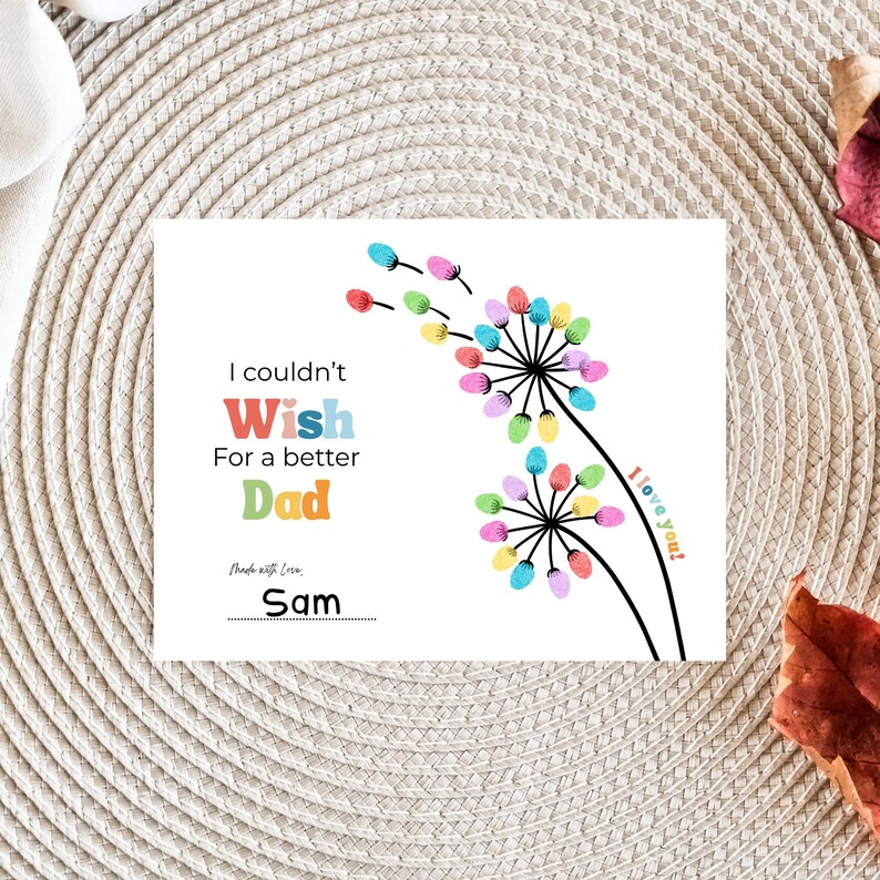 May include: A white greeting card with the text "I couldn't Wish For a better Dad." Colorful dandelion illustrations and the words "I love you!" are also featured. The card is signed "Sam."