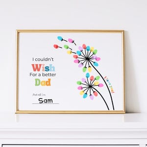 May include: A framed print with a gold border features a colorful dandelion design. The text reads "I couldn't wish for a better Dad" with the name "Sam" at the bottom. The words "I love you!" are also included.