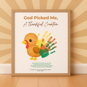May include: Framed artwork featuring a cartoon turkey with handprint feathers. The text reads "God Picked Me, A Thankful Creation." Additional text includes a Bible verse from Psalm 139:14. The artwork is in a light brown frame.