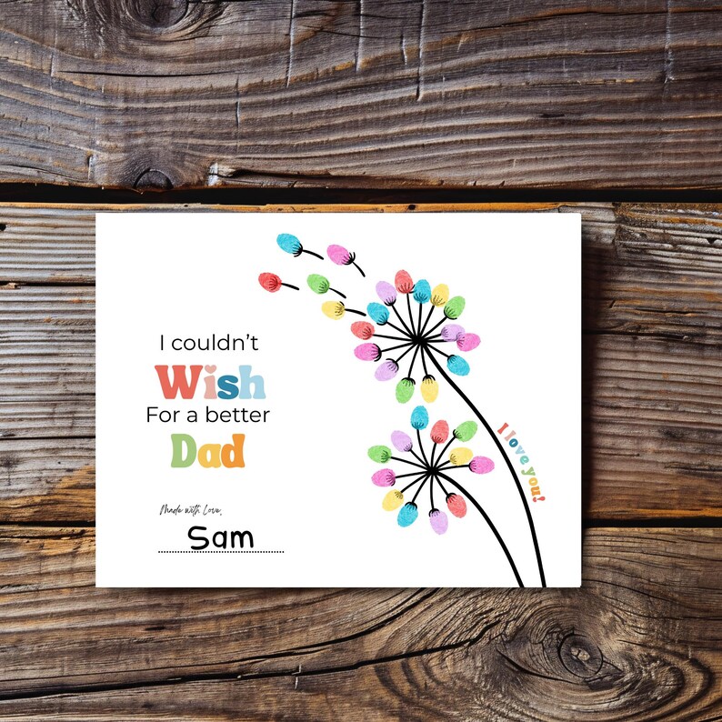 May include: A white greeting card with the text "I couldn't Wish For a better Dad" in colorful letters. The card features a dandelion design with colorful finger-print-like accents and the words "I love you!" and "Made with Love, Sam".
