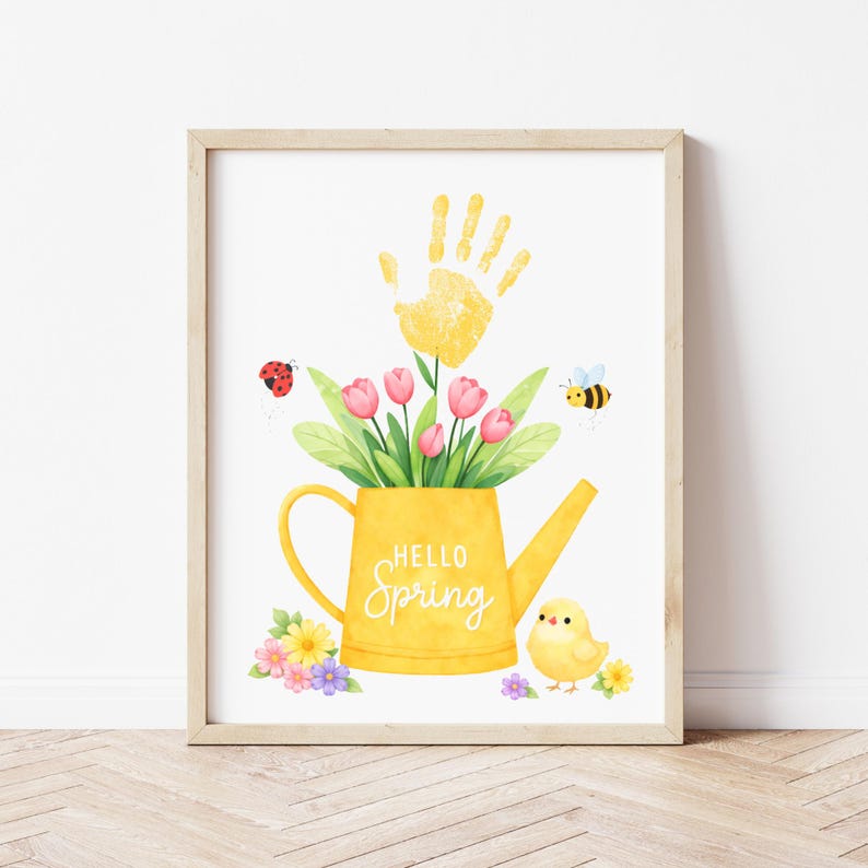 Puede incluir: Una impresi&oacute;n en acuarela enmarcada con una regadera amarilla llena de tulipanes rosas y hojas verdes. Una huella de mano amarilla est&aacute; encima de las flores. Tambi&eacute;n se incluyen una mariquita, una abeja y un pollito. El texto "Hello Spring".