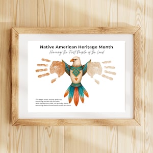 May include: A framed print titled Native American Heritage Month Honoring The First People of the Land. It features a central eagle illustration with teal and orange geometric patterns, flanked by light brown handprints and a short poem.