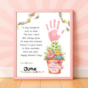 Può includere: Una stampa incorniciata con un bordo rosa presenta una poesia e un'impronta rosa. Sono inclusi anche una composizione floreale in un vaso e le parole "Happy Mother's Day". La parola "June" è scritta in basso.