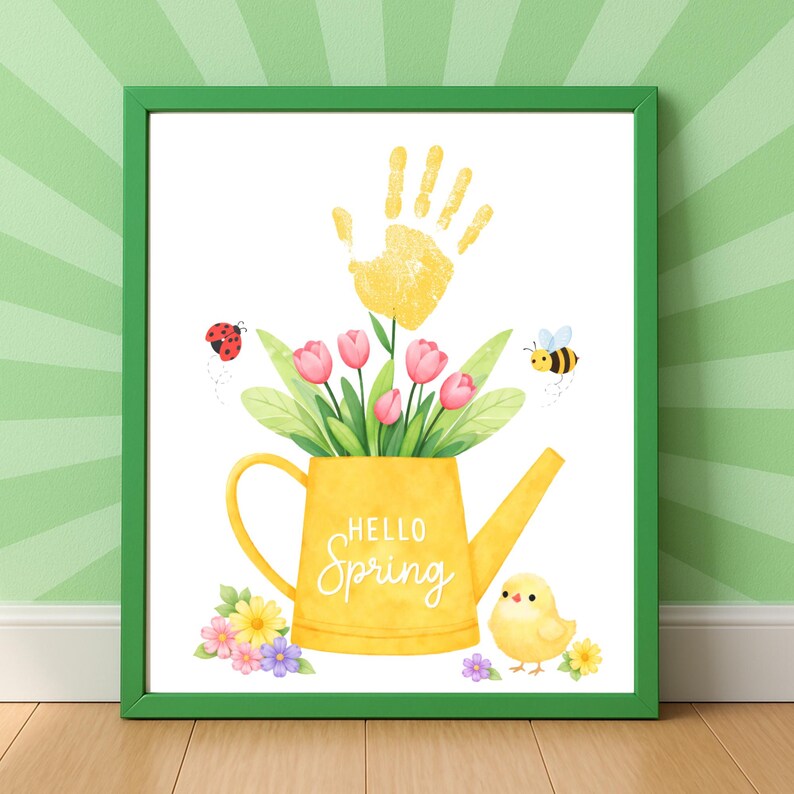 Puede incluir: Una impresi&oacute;n enmarcada con un borde verde presenta una regadera amarilla llena de tulipanes rosas y hojas verdes. Una huella de mano amarilla est&aacute; encima de las flores. Las palabras "Hello Spring" est&aacute;n en la regadera. Una mariquita, una abeja y un pollito tambi&eacute;n est&aacute;n en la imagen.