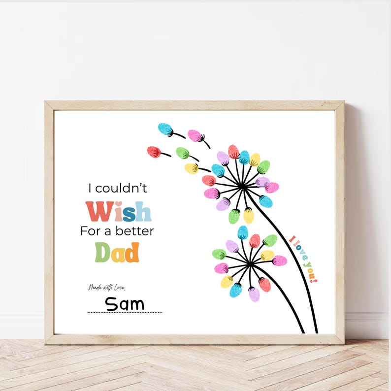 May include: A framed print with a white background features colorful dandelion-like designs made of fingerprints. Text reads "I couldn't Wish For a better Dad" with the name "Sam" below. The words "I love you!" are also included.